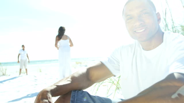 Retrato-de-joven-macho-étnicos-sentado-en-la-playa