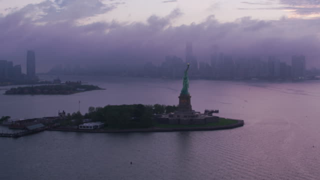 Volar-por-la-estatua-de-la-libertad-en-enfoque-a-Manhattan-en-temprano-en-la-mañana.
