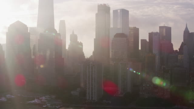 Verfolgung-durch-niedrigere-Manhattan-Gebäude-mit-niedrigen-Wolken-und-Sonne-am-frühen-Morgen.