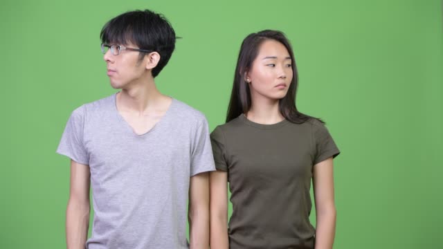 Junge-asiatische-Paar-zusammen-wegschauen