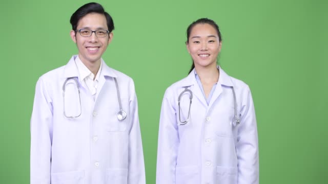 Médicos-de-la-joven-pareja-asiática-feliz-juntos