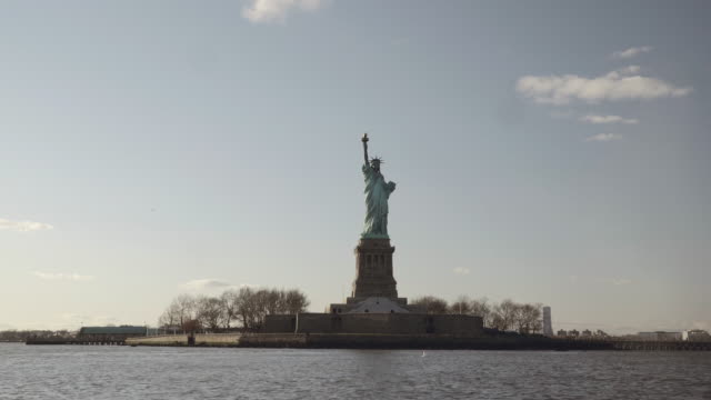 Halb-Breite-Schuss-der-Statue-of-Liberty,-gefilmt-in-den-Sonnenuntergang-vom-Fluss-in-New-York,-Vereinigte-Staaten-von-Amerika