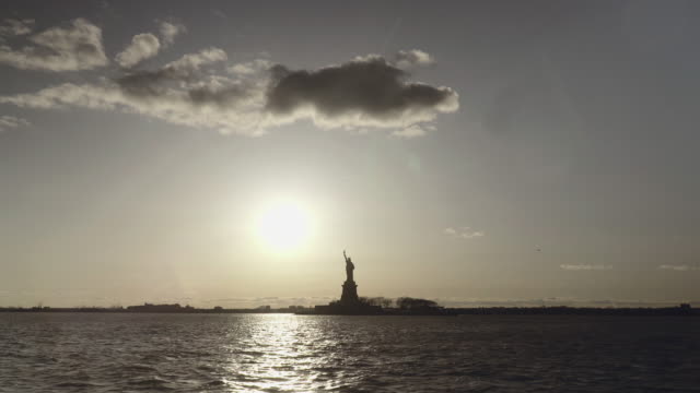 Extra-breite-Schuss-der-Statue-of-Liberty-gefilmt-in-den-Sonnenuntergang-vom-Fluss-in-New-York,-Vereinigte-Staaten-von-Amerika