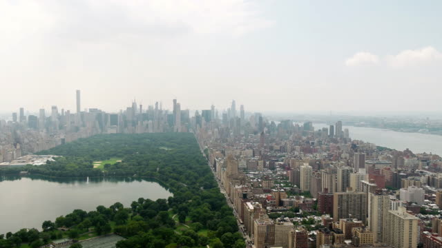 Central-Park-Luftaufnahmen-von-Gebäuden-über-grüne-NYC-nach-hinten-ziehen