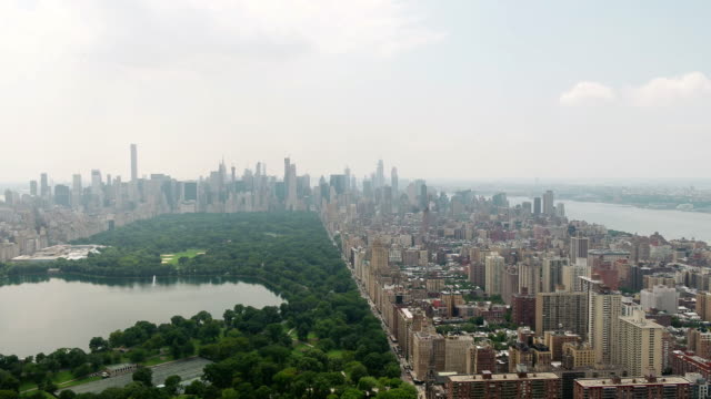Central-Park-rising-over-green-and-buildings-aerial-Manhattan-New-York-City