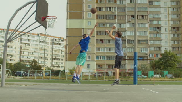 Jugadores-de-Streetball-tomando-tiro-de-salto-en-cancha-de-baloncesto