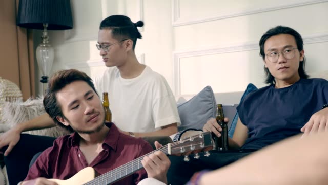 Gruppe-von-jungen-asiatischen-Musiker-sammeln-Bier-trinken-zu-Hause