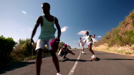 Gemischte-ethnische-Gruppe-von-teen-Skateboarder-racing-downhill-zusammen