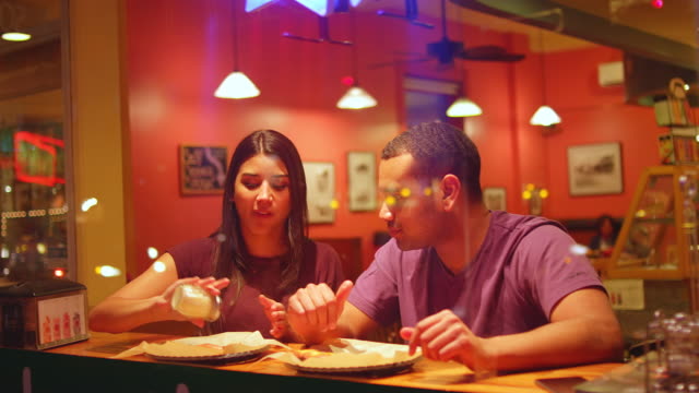 Una-joven-pareja-comiendo-en-un-centro-de-la-ciudad-de-pizzeria