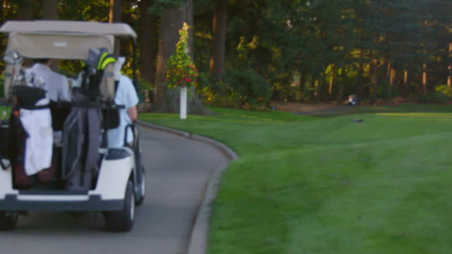 Zwei-Golfspieler-Fahrt-in-einem-Golf-Warenkorb.
