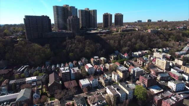 Cliffside-Park,-NJ-fliegen-über-Häuser-in-Richtung-Mehrfamilienhäuser-mit-blauem-Himmel