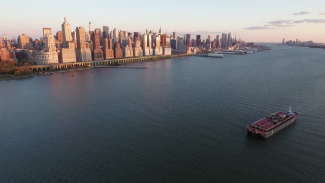 NYC-Aerial-Shot,-Fly-Backwards-Shot-Of-Upper-Westside-With-Red-Tug-Boat
