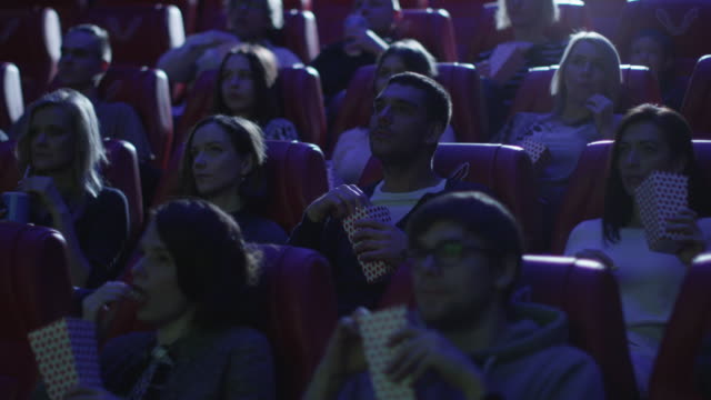 Group-of-people-are-laughing-while-watching-a-comedy-film-screening-in-a-movie-cinema-theater.