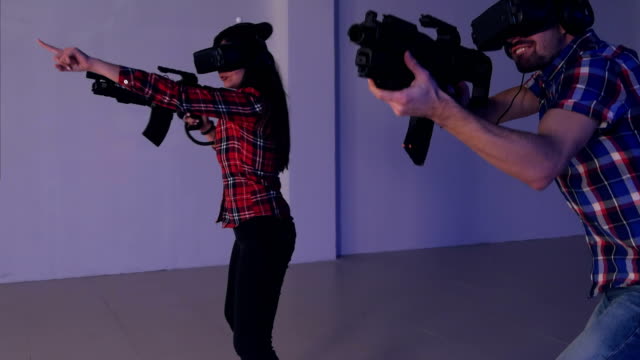Junges-Paar-VR-Shooter-Spiel-mit-virtual-Reality-Gewehren-und-Gläser