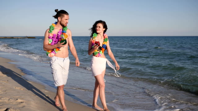 Caminar-descalzo-en-la-playa-de-arena,-par-en-bebida-de-amor-coloreada-cócteles,-viaje-romántico-de-Hawaii,-felicidad-gente-andando-en-el-resort