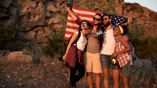 Viajeros-felices-tomando-selfie-con-bandera