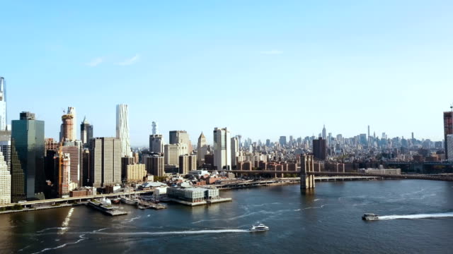 Vista-aérea-del-puente-de-Brooklyn-a-través-del-río-este-de-Manhattan-en-Nueva-York,-América.-Barco-en-la-orilla