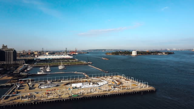 Vista-aérea-de-la-orilla-de-East-river-en-Nueva-York,-América.-Drone-volando-a-lo-largo-de-la-construcción-en-la-costa-en-Brooklyn