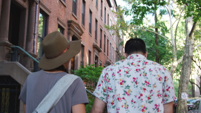 Vista-posterior-de-la-pareja-caminando-por-la-calle-urbana-en-la-ciudad-de-Nueva-York