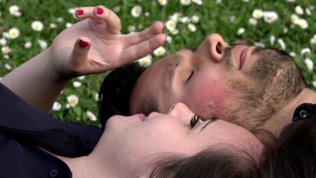 sweet-and-romantic-couple-lying-on-the-grass-chatting
