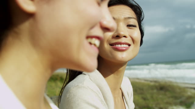 Laughing-multi-ethnic-female-friends-together-Fall-beach