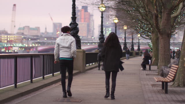 Vista-posterior-de-la-pareja-caminando-a-lo-largo-del-Banco-del-sur-en-visita-a-Londres