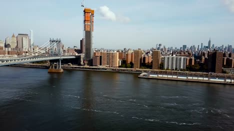 Vista-aérea-del-puente-de-Manhattan-y-el-distrito-de-Nueva-York,-América.-Girando-en-la-orilla-de-este-río-abejón