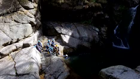 Abenteuer-sucht-Kletterer-schwimmen-über-einem-Wasserfall-Plunge-Pool