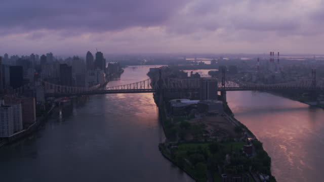 Flying-up-East-River-over-Roosevelt-Island-and-Queensboro-Bridge-at-sunrise.