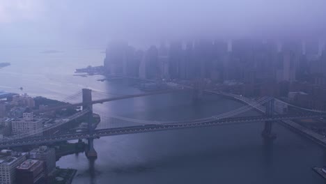 Flying-down-East-River-by-Brooklyn-and-Manhattan-bridges-in-foggy-morning.