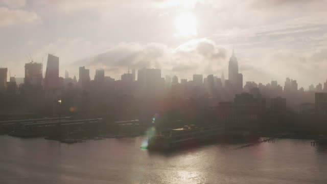 Flying-up-Hudson-River-at-sunrise-with-Manhattan-buildings-and-piers.
