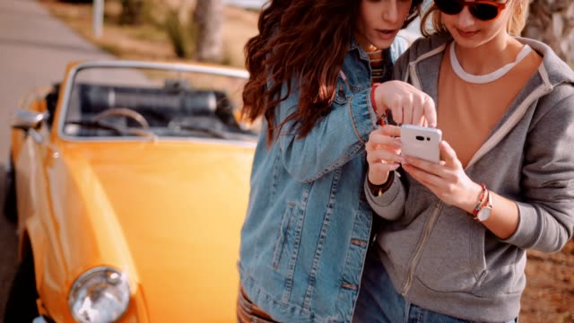 Mujeres-con-smartphone-y-leer-en-línea-mapa-de-viaje-por-carretera