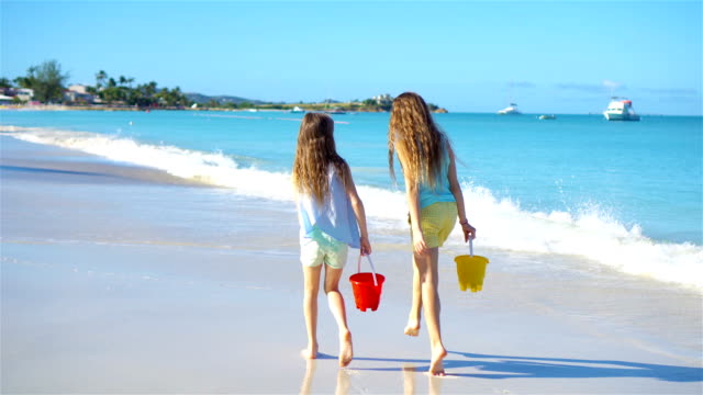 Adorables-niñas-caminando-por-la-playa-y-divertirse-juntos