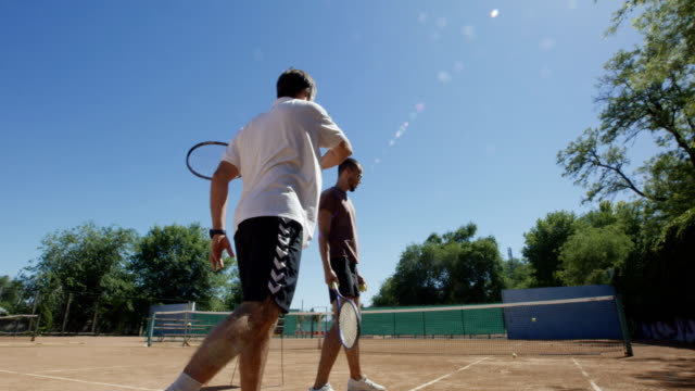 Men-playing-tennis-against-wall