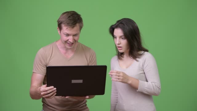 Young-man-using-laptop-with-young-woman-looking-shocked