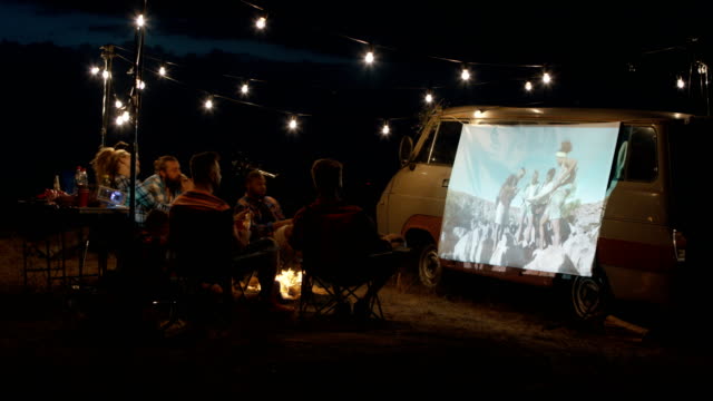 Amigos-viendo-la-película-en-el-camping