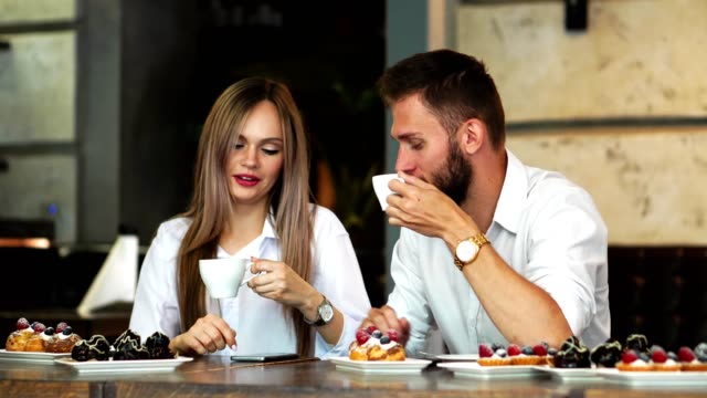 Man-and-woman-at-the-bar-having-a-coffee-and-using-a-mobile-phone