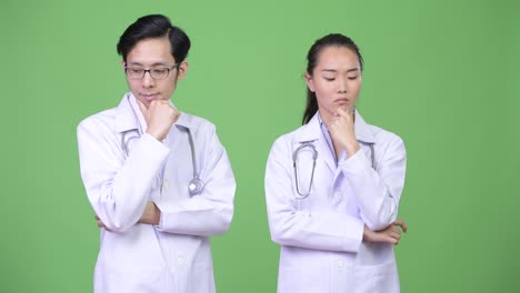 Médicos-de-la-joven-pareja-asiática-pensando-juntos