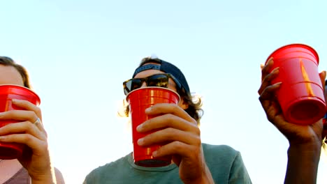 Group-of-friends-toasting-glasses-of-beer-in-the-beach-4k