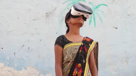 Young-teenager-girl-wearing-VR-virtual-reality-headset-working-games-enjoy-music-playing-engage-cinema-film-hands-point-cutting-edge-contemporary-wireless-communication-technology-surreal-India-rural