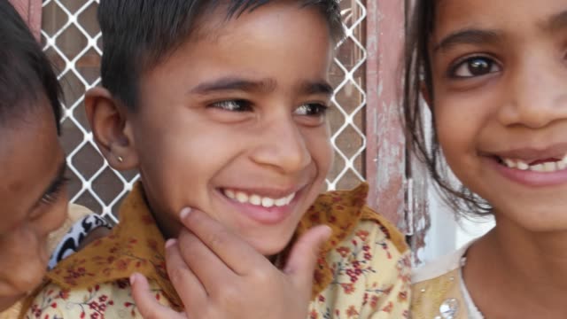 Schwenken-Sie-über-ein-paar-indische-Kinder-Lächeln-und-lachen,-handheld-closeup