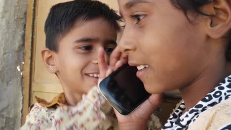 Indian-kids-talking-on-mobile-cell-phone,-excited-and-happy,-talking