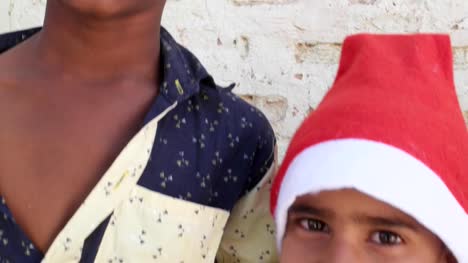 Close-up-of-two-kid-brothers-with-Santa-hats-smiling
