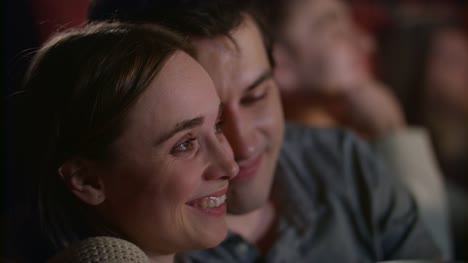 Young-couple-enjoying-film-in-cinema-embracing.-Love-couple-watching-movie