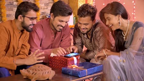 Buenas-colegas-de-oficina-buscando-utilizando-una-aplicación-o-ir-de-compras-en-línea-en-un-teléfono-celular-durante-Diwali
