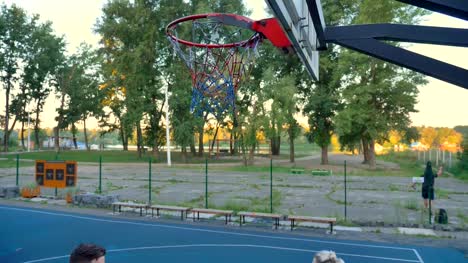 Beautiful-female-player-playing-one-on-one-with-man,-winning,-basketball-hits-ring,-park-in-background,-morning