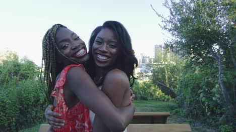 Slow-motion-of-two-African-American-women-hugging-and-smiling-at-camera-in-LA