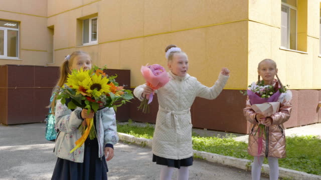Glücklich-Schulmädchen-mit-Bouquet-Blumen-springen-und-spielen-Frontkamera.