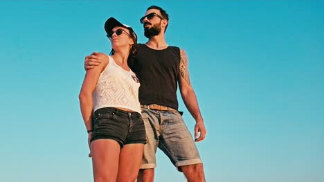 young-woman-and-man-enjoying-the-sunset-in-front-of-a-blue-sky