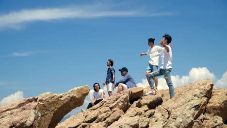 young-asian-adult-men-standing-on-top-of-rocks-by-the-sea